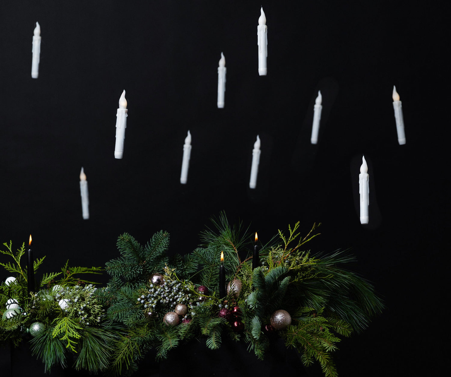 Decorative wreath with candles against a black background